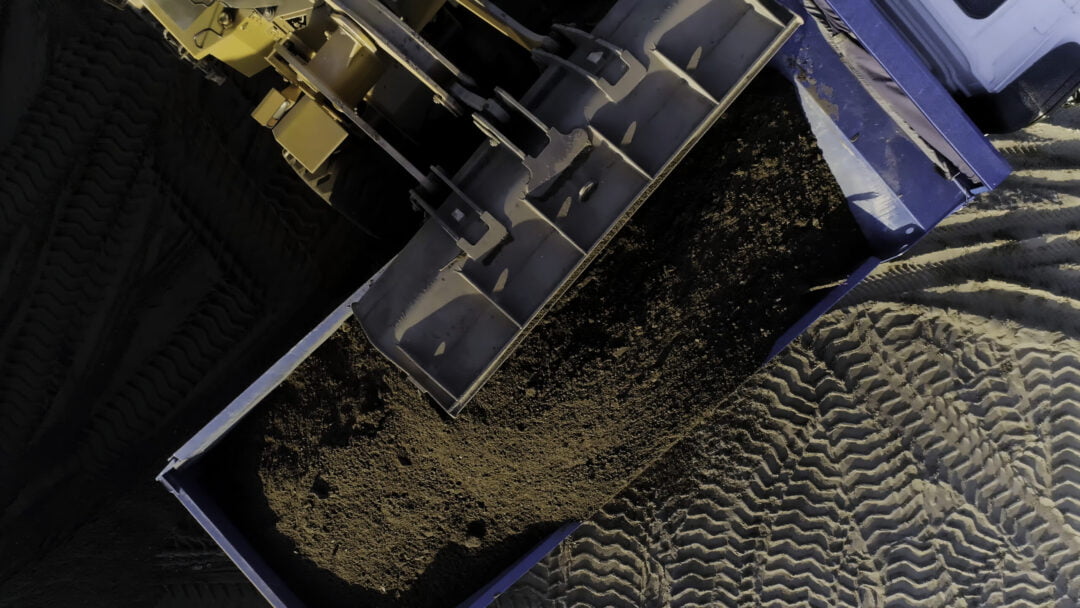 The construction process.Scene.Large machines in which cement lies and which are removed from a height load the cargo on an empty area and unload it for construction. High quality 4k footage